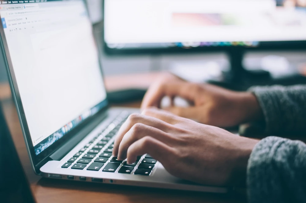Iemand werkt met informatie op een laptop.